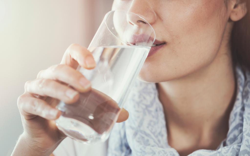 Woman drinks water to stay hydrated.