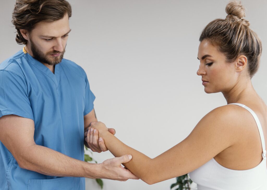 side view male osteopathic therapist checking female patient s elbow movement