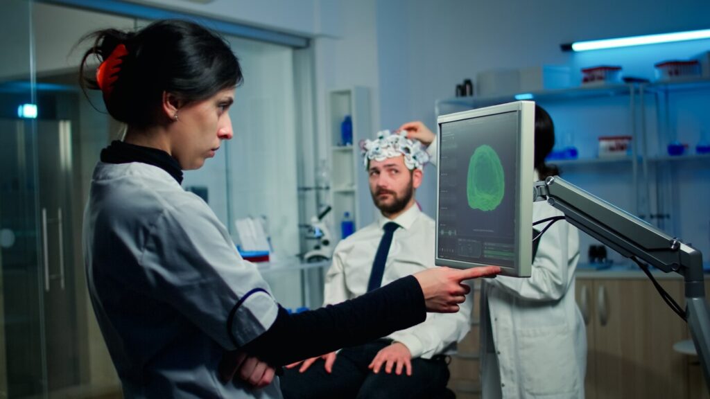 woman researcher looking monitor analysing brain scan while coworker discussing with patient background about side effects 482257 2073